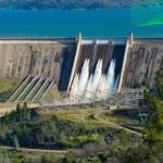 Usina hidrelétrica com faixa verde representando energia renovável.