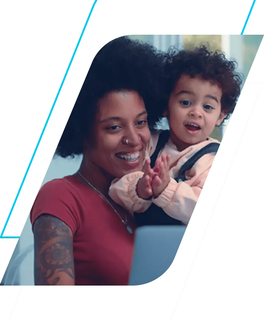 Fotografia de mãe segurando filho, sorrindo. Ela usa camiseta rosa escuro e o filho rosa claro.